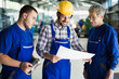 © NDABCREATIVITY - Team Of Engineers Having Discussion In Factory