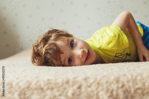 Beautiful Little Boy Lying On Bed And Looking Curly Cute
