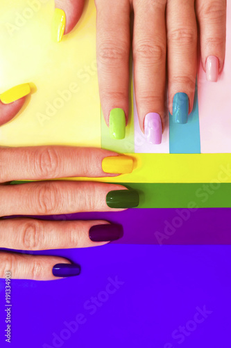 Foto Multi-colored pastel manicure combined tone on tone with a striped background