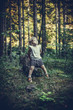 Little Girl Sitting Alone on a Rock in Forest