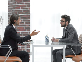 Wall Mural - business partners talking while sitting at your Desk