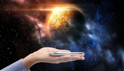 Wall Mural - hand holding smartphone over planet in space