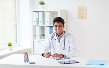 happy doctor with clipboard at clinic