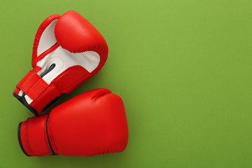 Wall Mural - Boxing gloves with blank space for gym exercise plan on color background. Flat lay composition