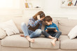 © Prostock-studio - Two kids listening music on couch at home