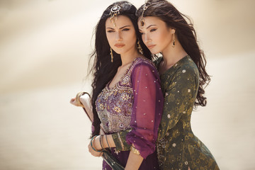 Travel concept. Two gordeous women sisters traveling in desert. Arabian girls.