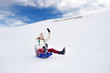 © Maria Sbytova - Happy middle age woman having fun during rolling down the mountain slope on sled in Alps