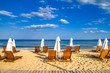 Coastal landscape - Beach umbrellas and loungers on the sandy seashore, the Kavatsi bay near city of Sozopol in Bulgaria