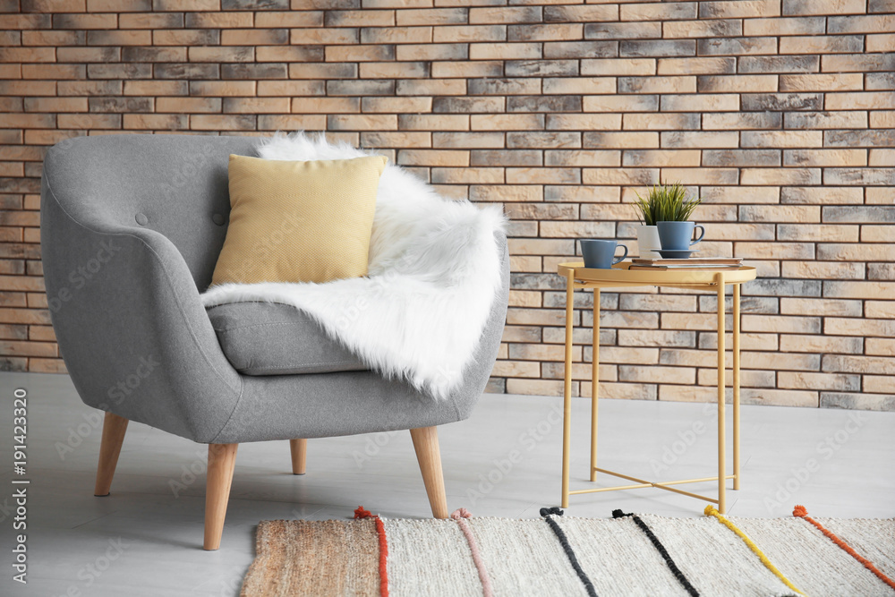 Beautiful trendy room interior with comfortable armchair and stylish table