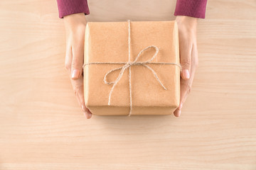 Woman holding parcel gift box on wooden background