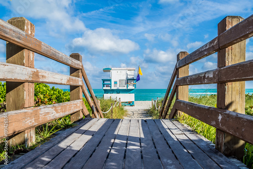 Plakat Na drewnianym molo ratownika stoją Miami plaża Floryda