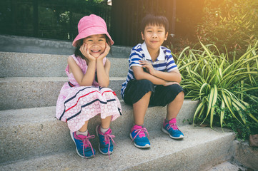 Wall Mural - Brother and sister smiling and looking at camera. Vintage tone.