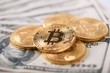 © serhiibobyk - Encrypted golden bitcoins presenting the biggest cryptocurrency worldwide nowadays lying on old hundred dollar banknotes. Digital virtual web currency electronic money blockchain mining exchange