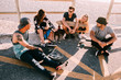 © Criene Images - Group of hipster friends hanging out at beach with skateboards