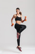 © Drobot Dean - Full-length photo of sporty woman workout with small dumbbells, isolated over gray background