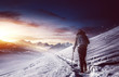 Hiker walking along snowy path in mountains