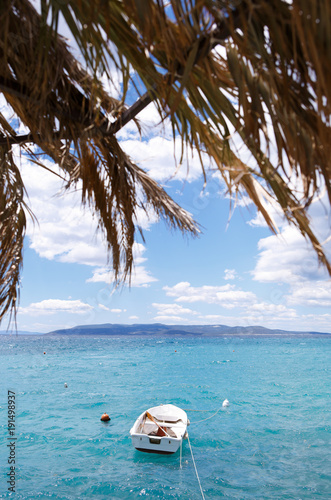 Small Boat Drifting In The Sea Under Palm Trees Beautiful Blue Sea