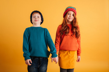 Wall Mural - Two funny little children wearing warm hats