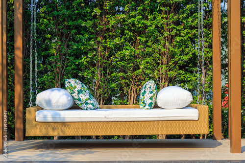 Fotografía An outdoor resin wicker porch swing in the garden with nature background