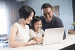 Happy Asian family using the computer together at home.