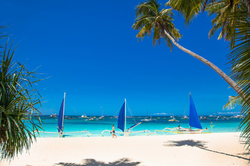 Philippine traditional boat with blue sail on White Beach. Boracay, Philippines.