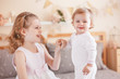 © anoushkatoronto - Two cute adorable white Caucasian girsl sisters smiling laughing. Children sitting together on bed in bedroom playing. Lifestyle real true emotions, sibling love