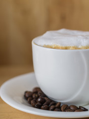 hot coffee in white cup on table with coffee beans