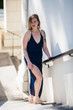 © motionshooter - Alluring young woman in sheer blue dress ascending stairs with sexy leg revealed.