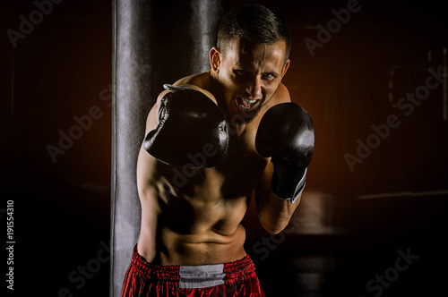 Foto Professional sportsman of mixed martial arts stands in the fighting stance and beats with the krim on the enemy