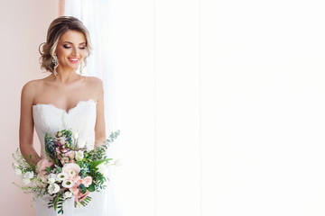portrait of a beautiful bride with a wedding bouquet. blonde girl with curly hair and fashion makeup