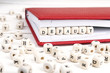 Word Default written in wooden blocks in red notebook on white wooden table.