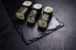 sushi rolls with salmon covered in nori on dark background. Japanese restaurant menu. Delicious traditional eastern food