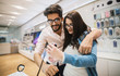 © dusanpetkovic1 - Hipster indecisive couple checking out mobile phones in the electronic shop.