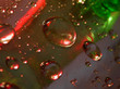 The texture of the shiny surface with large and small drops of water with red and green backlighting