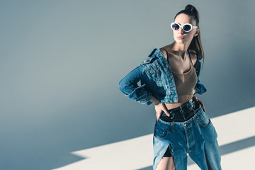 fashionable brunette model posing in denim style and sunglasses