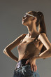 © LIGHTFIELD STUDIOS - fashionable girl posing in sunglasses with ponytail hairstyle, isolated on grey