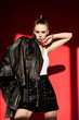 © LIGHTFIELD STUDIOS - stylish caucasian girl posing in black leather jacket for fashion shoot on red
