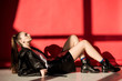 © LIGHTFIELD STUDIOS - beautiful stylish model lying in black leather jacket on red