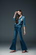 © LIGHTFIELD STUDIOS - beautiful smiling girl with long hair posing in flare jeans, on grey