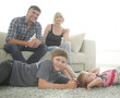 © ASDF - Portrait of children while parents sitting at sofa in living roo