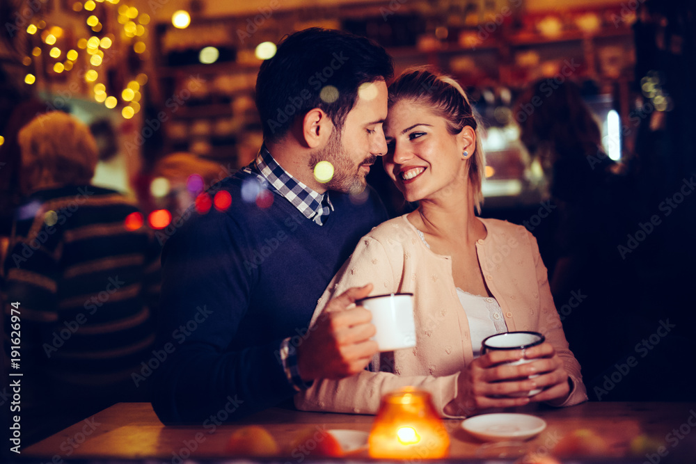 Romantic couple dating in pub at night - obrazy, fototapety, plakaty 