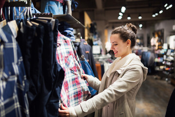 Young attractive woman buying clothes in mall