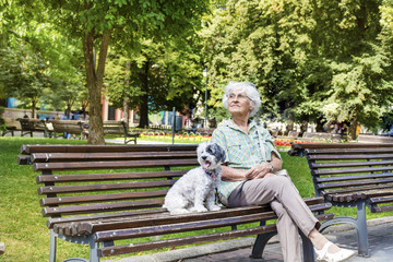 Beautiful Senior Woman Hugging her Cute Dog in the Park