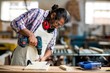 © Wavebreak Media - Carpenter drilling a hole in a wooden plank