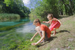 Girl and boy siblings playing near water of Italian Tirino river in Abruzzo