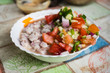 Tipical raw fish dish, ceviche. With vegetables, onion, red and green pepper, tomato and lemon juice