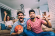 © Mediteraneo - Happy friends or basketball fans watching basketball game on tv and celebrating victory at home.Friendship, sports and entertainment concept.