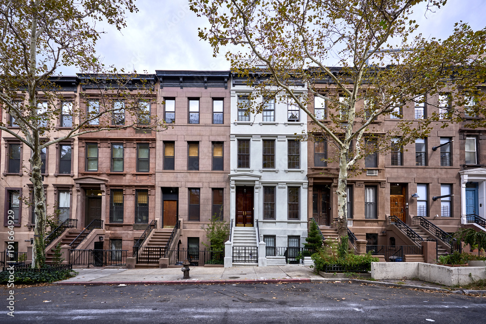 a view of a row of historic brownstone buildings in an iconic neighborhood of Manhattan, New York City - obrazy, fototapety, plakaty 