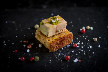 Wall Mural - isolated foie gras toast on black plate with sea salt sprinkles