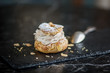 Paris Brest french cream cake pastry isolated on black plate sprinkled with almonds 
